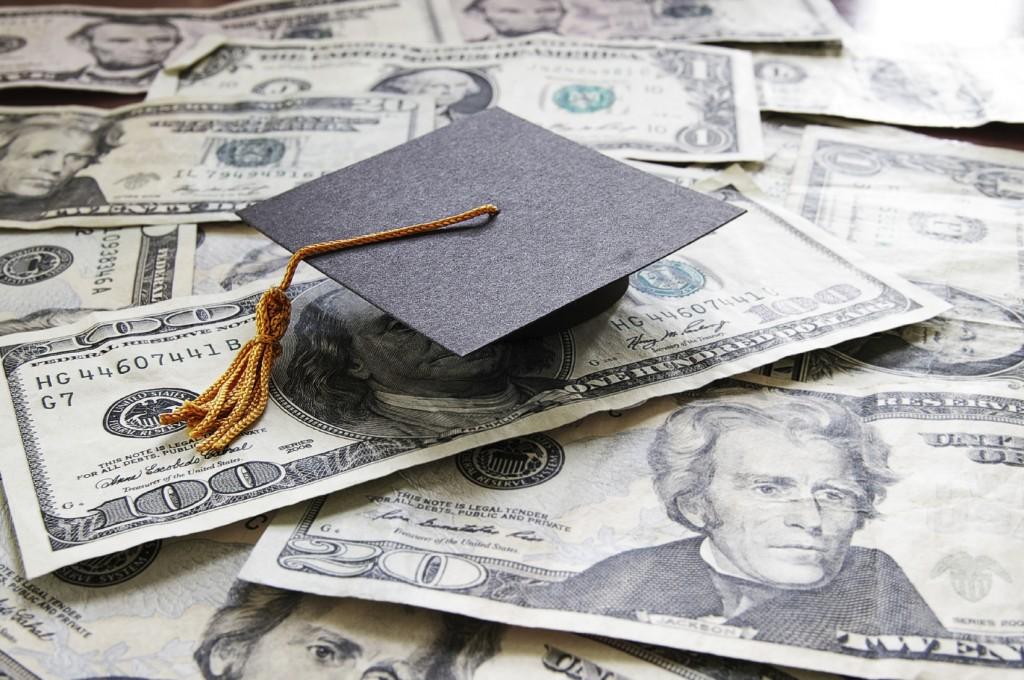 mini college graduation cap on cash