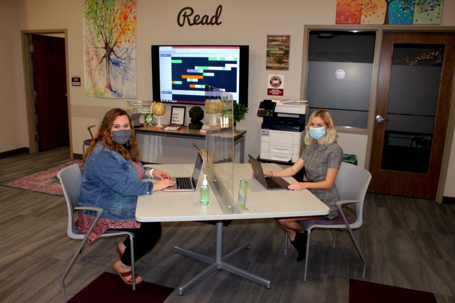Alyssa Bileck, consultant supervisor at Gannons Writing & Research Center, and Nicole Borro, assistant director, sit at a socially distanced table in the center, located in the lower level of the Nash Library. It is open Monday through Friday and Sunday nights.