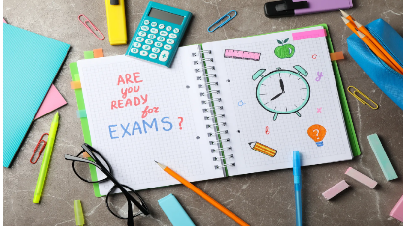 "Are you ready for exams?" written on a notepad surrounded by school supplies.