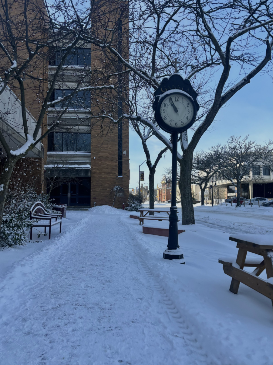 The foot prints of students walking to class imprinted in the snowy sidewalk in front of Zurn.